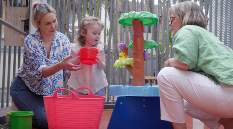 Child participating in a play-based early intervention session with a parent and clinician.