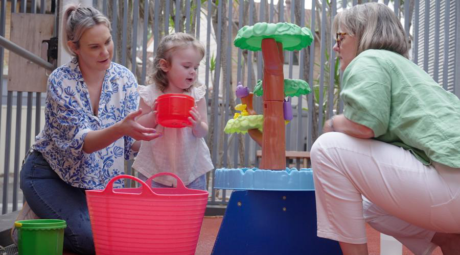 Child participating in a play-based early intervention session with a parent and clinician.